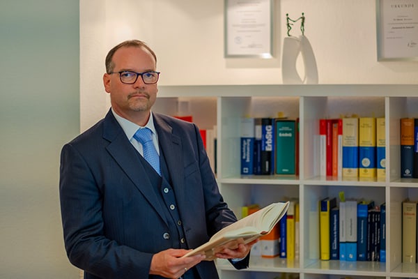 Dr. Hosser steht vor einem Bücherregal - probate law germany